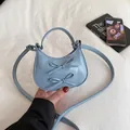 Borsa a mezzaluna in vernice azzurra con fiocchi decorativi e tracolla sottile - Blu