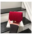 Detail view of red velvet quilted bag featuring luxury gold chain and metallic buckle - Red