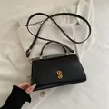 Bolso retro de cuero negro con cierre giratorio dorado y una correa delgada - Negro