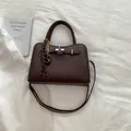 Donkerbruine handtas van leer met lychee-patroon, zilveren sluiting en zijden sjaaldetail - Bruin met Hanger