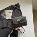 Borsa a trapezio grigio scuro in pelle martellata con chiusura a rotazione dorata - Grigio