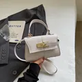 Elegante borsa a trapezio bianco burro con chiusura girevole dorata e trama a grana - Bianco avorio
