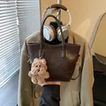 Brown vintage texture underarm bag with a plush Top Dog pendant accessory - Brown with Pendant