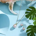 Detail of pink pearl necklace and earrings set with gold chain on a sea shell background - Light Pink (HWNX8841-6)