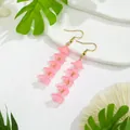 Macro detail of pink bellflower resin earrings with gold hooks on a white stone background - Long / Pink Long (HWX305PL)