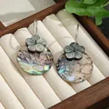Detailansicht der schillernden Abalone-Ohrringe mit schwarzer Muschelblume und Silberhaken - Silber Blume Runde Abalone-Muschel Stil (HWB884)