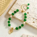 Detailed macro of green stone beads and white pearls bracelet with gold spiral charm - Nautilus Style (HWB0461)