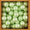 Makro-Detail von minzgrünen Perlen mit Löchern für die DIY-Schmuckherstellung - 8mm Halbbohrung