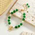 Close-up of vintage green jade beads and pearls with gold floral pendant on stone - Five-Petal Flower Style (HWB0464)