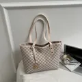 Chic M-patterned tote bag with gold metal charm on a desk with headphones - Off White