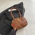 Braune Handtasche aus Leder mit Litschi-Maserung, rotem Herzanhänger und Silber-Hardware - Braun