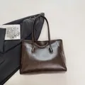 Bolso tote grande marrón oscuro en cuero sintético texturizado sobre blazer formal - Marrón