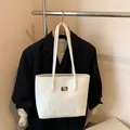 Borsa tote bianca lucida minimalista con doppi manici e dettaglio targhetta metallo - Senza Ciondolo / Bianco