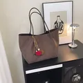 Large dark brown suede tote bag with pompom charm in a modern minimalist home setting - Coffee With Pendant