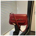 Detail view of red vintage leather shoulder bag with golden horsebit buckle hardware - Red