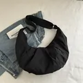 Bolso bandolera media luna negro minimalista de nailon con textura plisada y correa - Negro