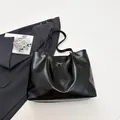 Minimalist black tote bag with silver bow detail and large capacity for commuting - Black