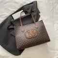 Brown monogram tote bag with embossed M logo on a professional black blazer background - Brown
