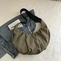 Sac croissant vert olive en nylon plissé avec une large bandoulière noire minimaliste - Vert
