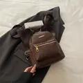 Zaino da donna in pelle PU intrecciata marrone scuro con stile vintage e zip dorate - Marrone
