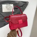 Red crossbody handbag with crocodile texture flap and gold hardware details - Red
