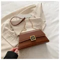 Elegante braune Leder-Pillow-Bag mit goldener M-Schnalle und Kettenriemen - Braun