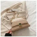 Elegant apricot pillow bag with golden M buckle and chain strap on a blazer - Khaki