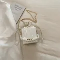 Mini weiße Beuteltasche mit großem Perlengriff und goldener Kette bei sanftem Licht - Weiß