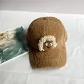 Detalle de gorra de béisbol marrón de lana con lindo decorado de oveja blanca de dibujos - Caqui