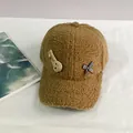 Detalle de la gorra de forro polar marrón con parche de conejo y lazo de cuadros - Talla Adulto (Ajustable) / Caqui