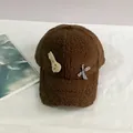 Detalle de gorra de felpa para invierno con parche de conejo y lazo de cuadros - Talla Adulto (Ajustable) / café