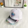 Detalle de gorra con corazón de purpurina y pedrería arcoíris en la visera - Adulto (56-60cm Ajustable) / Blanco