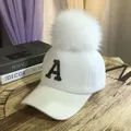 Dettaglio del berretto invernale bianco con morbido pompon e lettera A di paillettes luccicanti - Adulto / Bianco