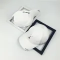 Dettaglio di cappellini in cotone bianco con anelli, ciondolo Torre Eiffel e ricamo Paris - Bianco