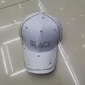 Cappellino bianco con catena dorata e scritta BLACK decorata con strass luminosi - Bianco