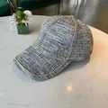 Grey tweed baseball cap with gold M logo and chain trim decoration on white surface - Black