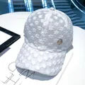 Weißes Damen-Basecap aus floraler Spitze mit Stickerei und goldenem M-Logo-Detail - Weiß M Rundlogo