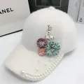 Détail de la casquette en peluche blanche avec fleurs, perles et broche de cerf - Réglable / Blanc