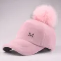 Detailansicht der rosa Plüsch-Baseballkappe mit Pelzbommel und silbernem M-Metall-Logo - Erwachsene / Rosa