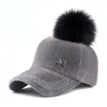 Detailansicht der grauen Plüsch-Baseballkappe mit Pelzbommel und Metallbuchstaben M - Erwachsene / Grau Mit Schwarzem Pompon