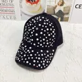 Dettaglio ravvicinato di un cappello nero con perle bianche e strass brillanti - Regolabile / Nero