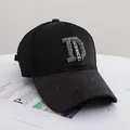 Detail der schwarzen Baseballkappe mit Strass-D-Logo und glitzernder Textur am Schirm - Erwachsenengröße (56-58cm) / Schwarz