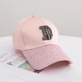Detail der rosa Baseballkappe mit Strass D-Logo und Glitzerrand auf Modemagazin - Erwachsenengröße (56-58cm) / Rosa