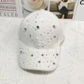 Dettaglio cappello in peluche bianco decorato con strass luminosi e perle preziose - Regolabile / Bianco