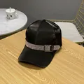 Detail of black satin baseball cap with rhinestone band and metal buckle on wooden surface - Adult Size (Adjustable) / Black
