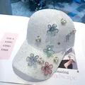 Detalle de gorra de lentejuelas blancas con flores de encaje y botones de perlas - Talla Adulto (Ajustable) / Blanco