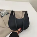 Minimalist black crescent hobo bag in soft pebbled leather with silver hardware finish - Black