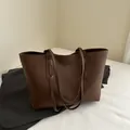 Dark brown matte leather tote bag with slender straps and a minimalist design - Brown