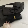 Bolso baguette negro con solapa ondulada y hebilla metálica dorada en forma de U - Negro