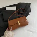 Bolso de hombro en cuero marrón caramelo con hebilla ovalada dorada y estilo minimalista - Marrón